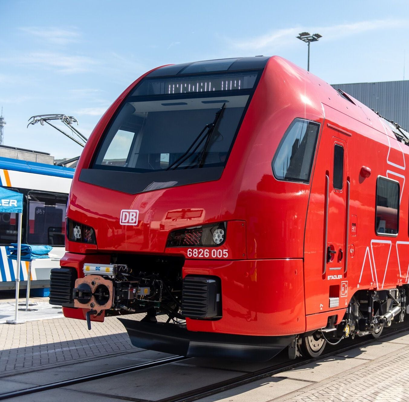 Rote Bahn auf einem Abstellgleis, dahinter ein Fabrikgebäude