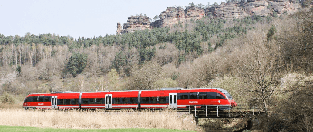 Eine Rote bahn fährt durch eine bewaldete Landschaft
